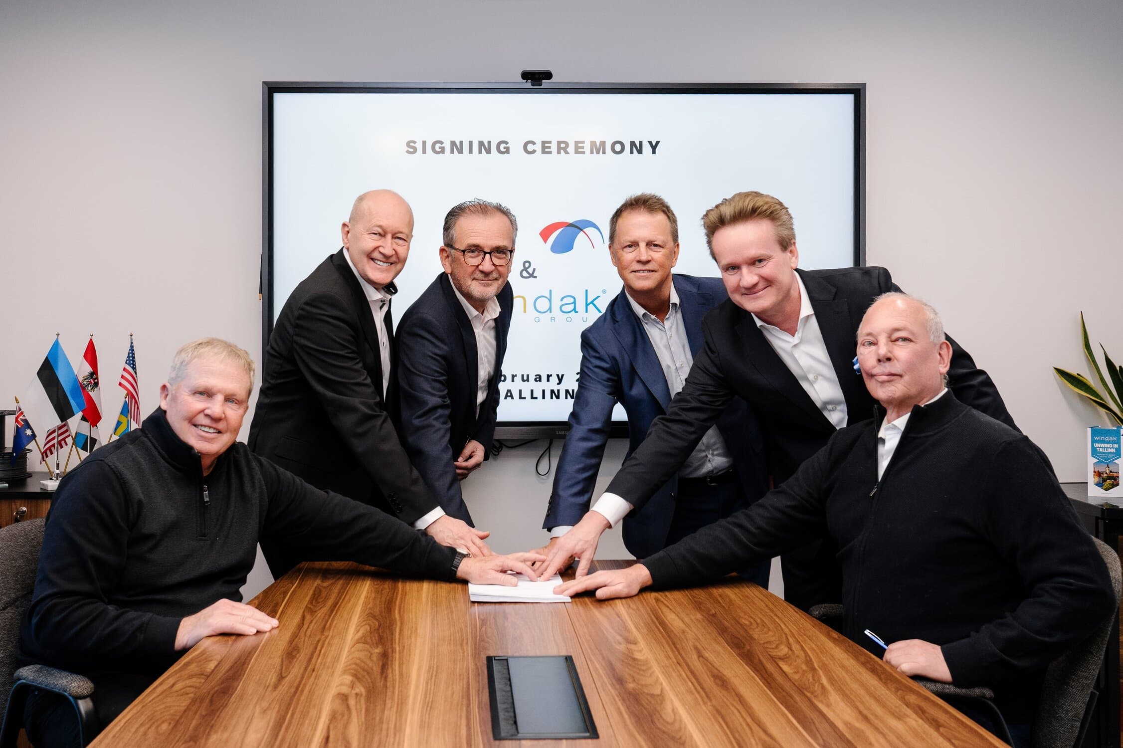Innovative business signing ceremony with six executives in a modern conference room, representing Rosendahl Nextrom's commitment to technological advancement and industry leadership.