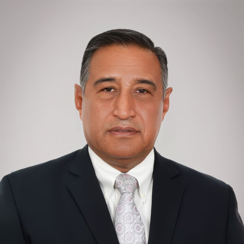 A professional portrait of a confident businessman in a dark suit and patterned tie, representing Rosendahl Nextrom's leadership in innovative fiber optic and cable manufacturing solutions.