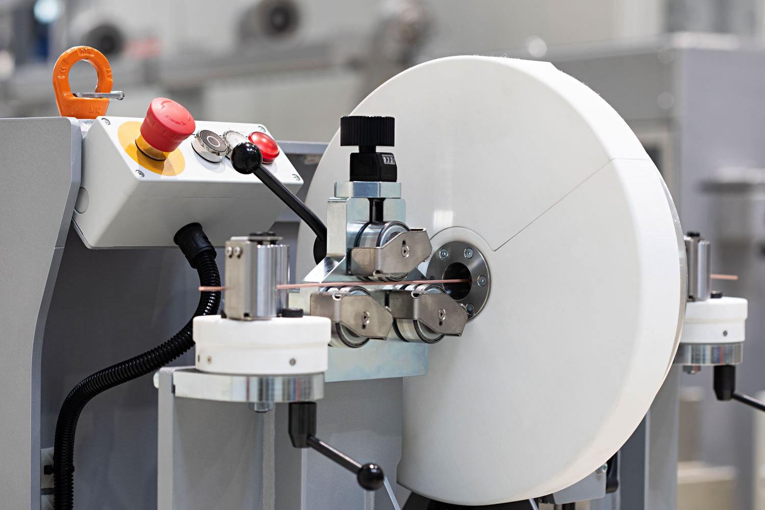 A machine used in industrial manufacturing, featuring a large white roll, control buttons, and precision components for processing materials in a clean, professional environment.