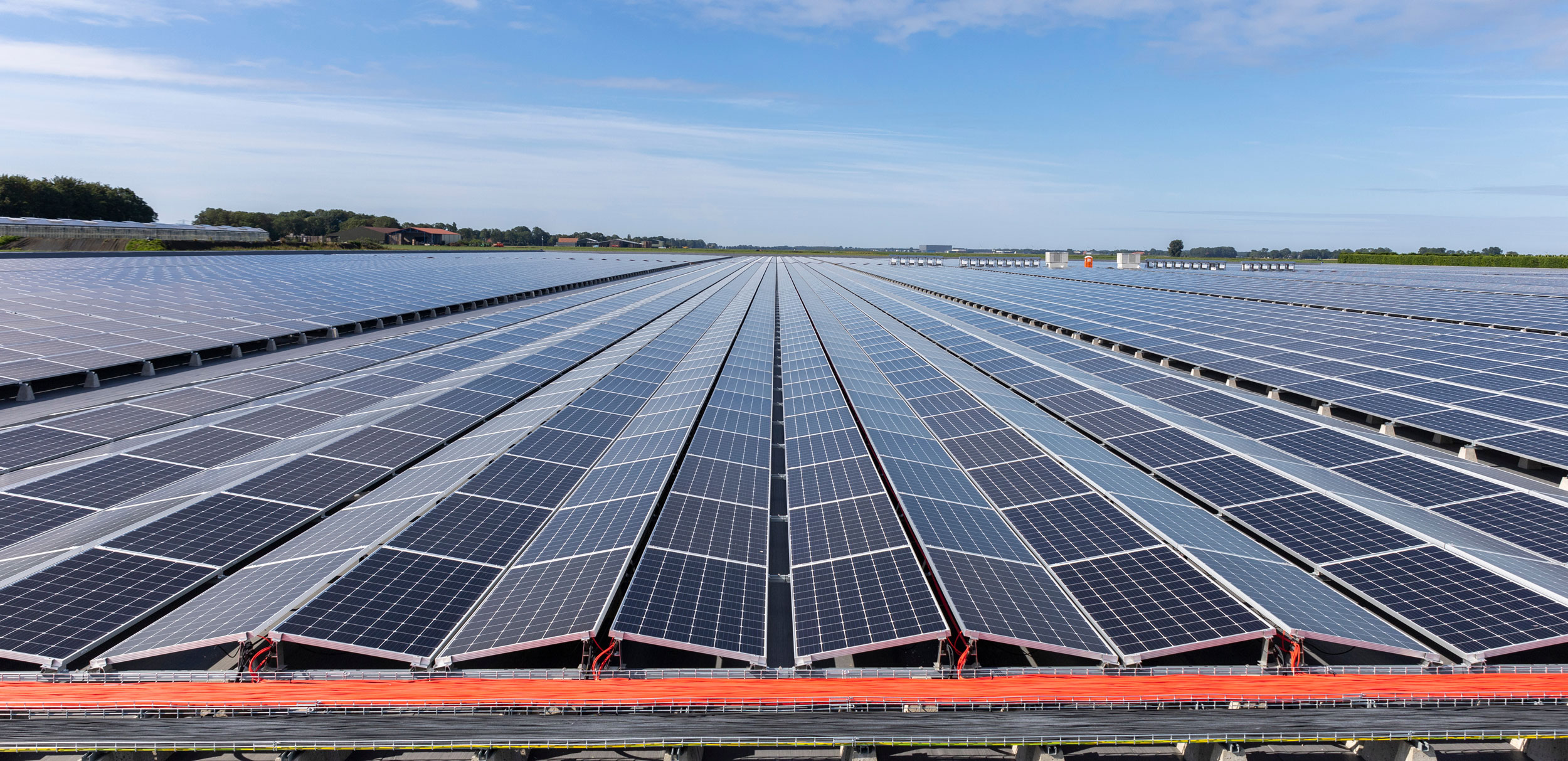 Solar panels installed on a large solar farm under a clear blue sky, showcasing renewable energy technology by Rosendahl Nextrom.