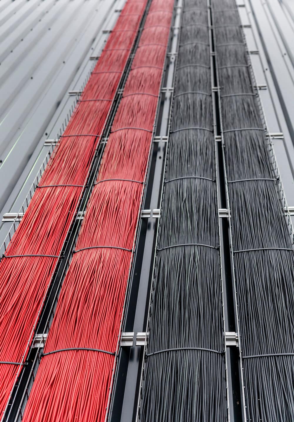 Red and black electrical cables installed on a solar panel or industrial setup, showcasing high-quality wiring and infrastructure for renewable energy or electrical systems.